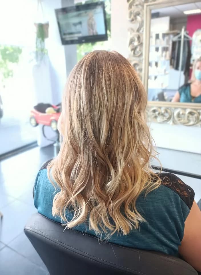 Balayage blond doré sur cheveux longs bouclés